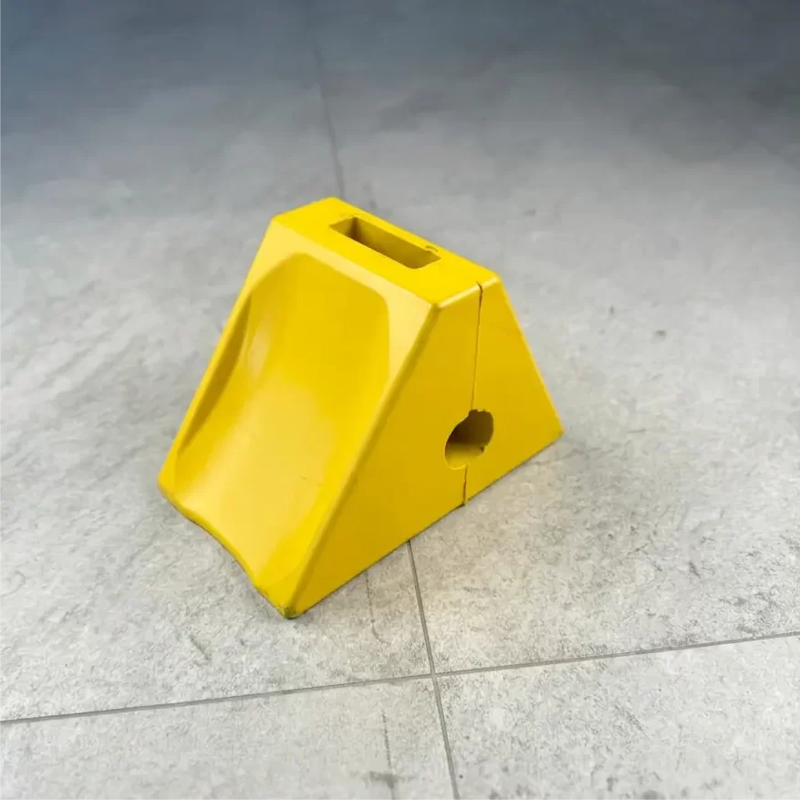 Heavy duty rubber wheel chock placed against HGV lorry tyre at loading dock