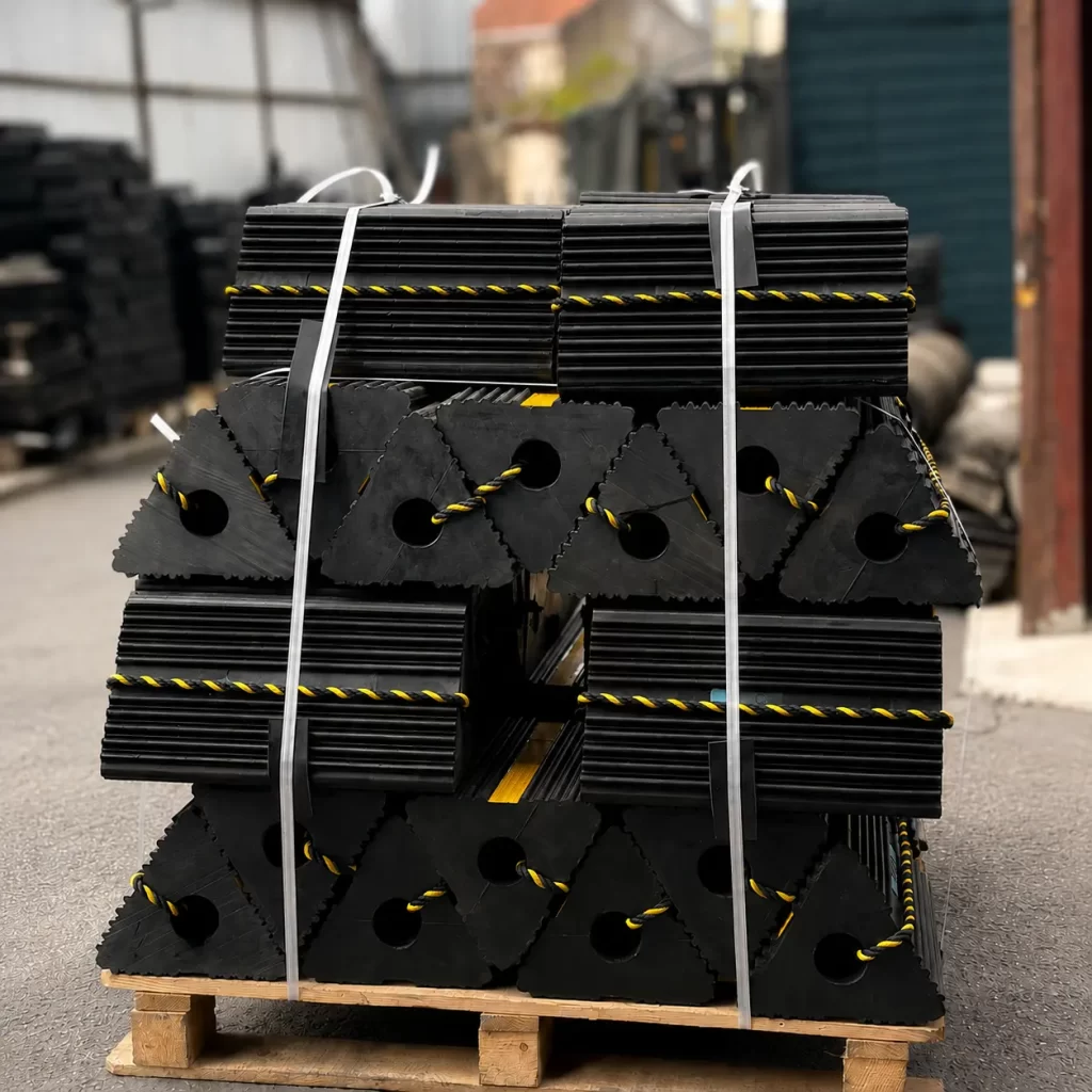 Heavy-duty triangular rubber aircraft chocks placed under the wheel of a commercial airplane on the airport ramp.
